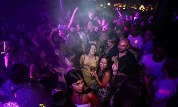 People drink on the dance floor shortly after reopening in London.