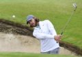 Tommy Fleetwood practices out of a green side bunker on the 6th hole at Sandwich.