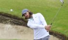 Tommy Fleetwood practices out of a green side bunker on the 6th hole at Sandwich.