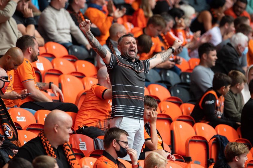 Dundee United fan with arms outstretched.