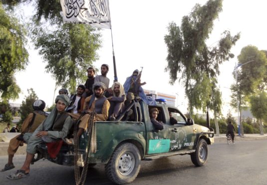 Taliban fighters patrol inside the city of Kandahar.