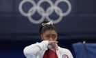 Simone Biles, of the United States, watches other gymnasts perform at the Tokyo Olympics.