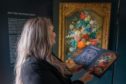 Kirsty McKay (Activity Engagement Officer PKAVS) studies the history of Jan van Huysum's magnificent painting, Flowers in a Terracotta Vase (1736–7) whilst on display at the Walled Garden in the grounds of the Murray Royal Hospital. Picture: Kenny Smith/DCT Media.