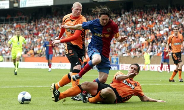 Dundee United's Lee Wilkie slides in to stop Lionel Messi. This time.