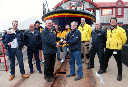 Ron Churchill (right) receives his 40-year long service medal from Arbroath lifeboat operations manager Alex Smith. Pic: Wallace Ferrier.