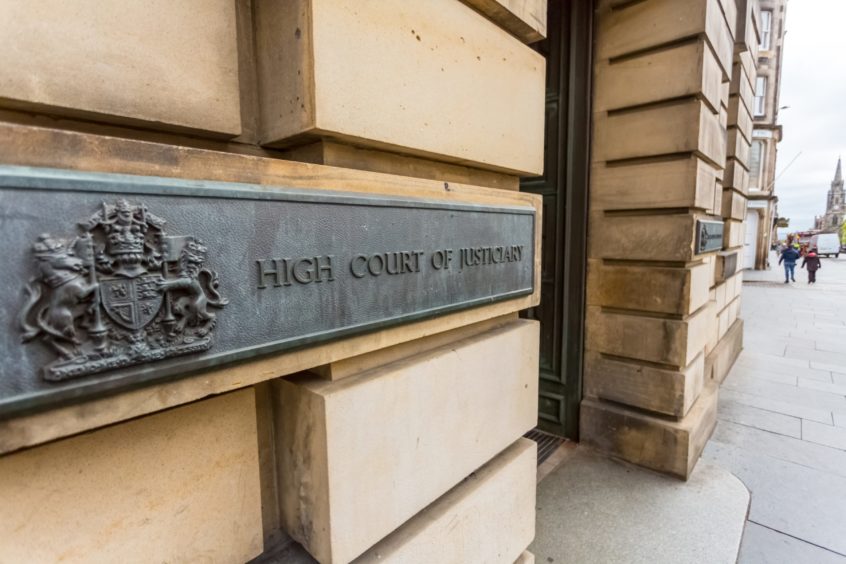 Photo shows a sign for the High Court of Justiciary on the wall of the building in Edinburgh.