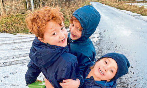 Photo shows three small boys, the sons of Martel Maxwell, playing in the snow.
