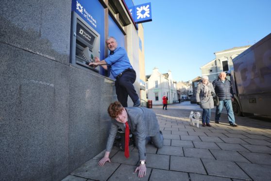 Tele reporters Kenny MacDonald and Matteo Bell attempting to use the cash machine.