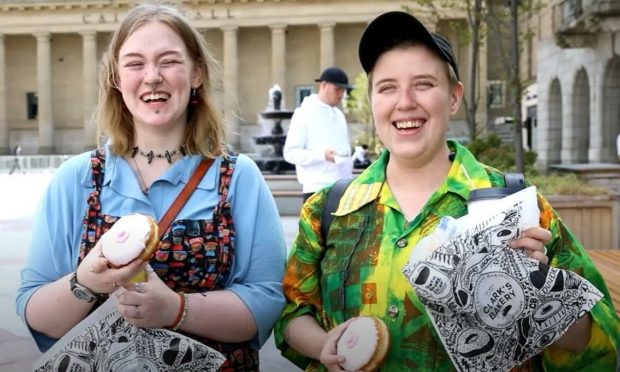 Paige Barclay and Ace Saunders try Clark's doughnuts.