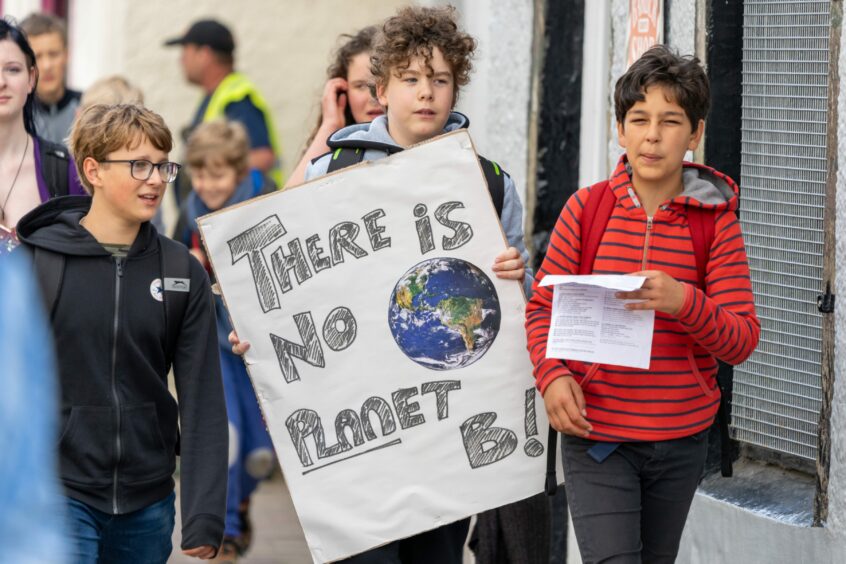 young boy carrying a handmade sign which reads 'There is no Planet B'.