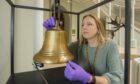 Curator Meredith Greiling with the Extinction Bell