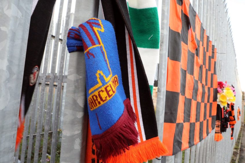 Scarves and other items left by fans at Tannadice yesterday.