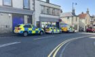 Police and ambulance vehicles in High Street Aberdour during the incident.