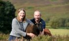 Sabrina and George Ross with one of their black Cheviot sheep.