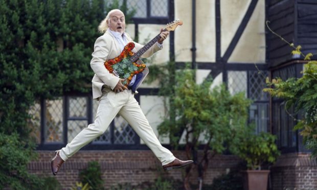 Bill Bailey with a guitar covered with flowers during the opening RHS Garden Wisley Flower Show in Woking. Picture by PA.