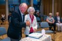 Founding figures Derick Gourlay and Margo Geddes cut the Monifieth Befrienders 21st anniversary cake. Pic: Steve Brown/DCT Media.