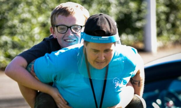 Connor Wilson gets a lift at The Yard from play team leader Helen Bonnar.