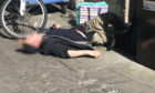 This shocking image of a drug user passed out with a used syringe in his hand while lying in Bank Street emerged on Tuesday.