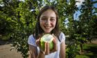 Murroes primary pupil Evie Peoples, 11, with an apple from one of the school trees. Pic: Mhairi Edwards/DCT Media.
