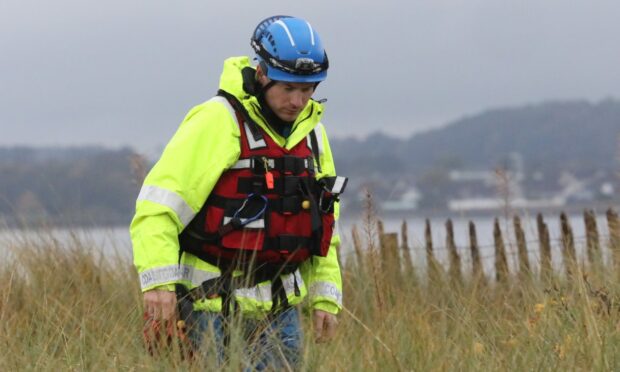 A coastguard worker searching the shore at Broughty Ferry.