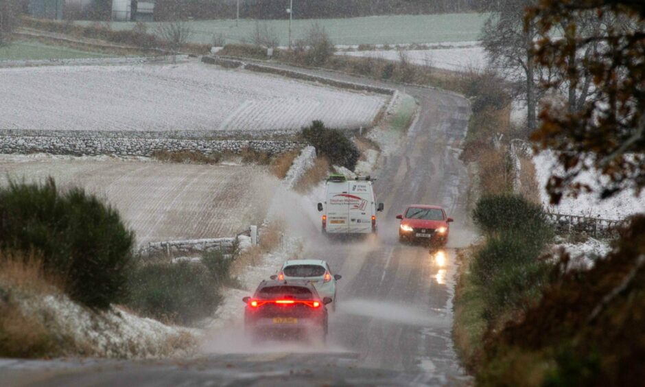 Cars driving through wet and wintry conditions at Carmyllie in Angus.