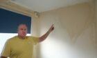 Paul showing the damp in his living room in Dundee.