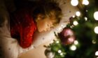 Child asleep on Christmas Eve.
