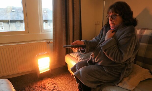 Anne McDonald has to wear a dressing gown and use an extra heater to keep warm.