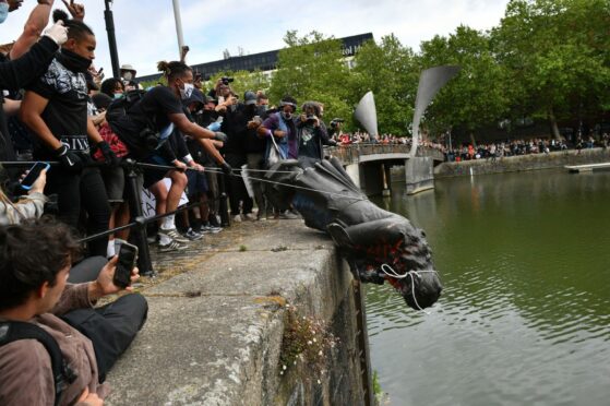 Protesters throw statue of Edward Colston into Bristol harbour. PA Photo.
