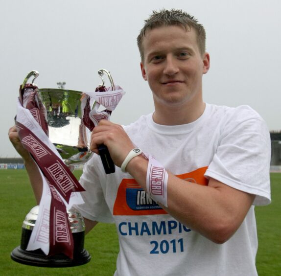 Steven Doris holds the third division trophy in 2011.