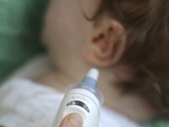 An eight month old baby boy having his temperature taken with a digital ear thermometer as research finds children who take paracetamol during their first two years of life may be at a higher risk of developing asthma by the age of 18, especially if they have a particular genetic makeup.