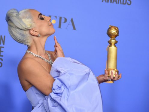 Lady Gaga poses in the press room with her Golden Globe for best original song (Jordan Strauss/Invision/AP)
