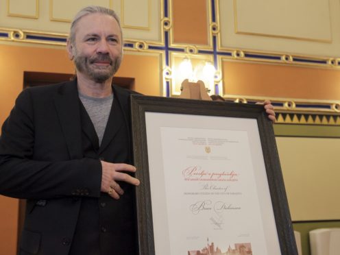 Bruce Dickinson with his honorary citizen certificate at the city hall in Sarajevo, Bosnia-Herzegovina (Eldar Emric/AP)
