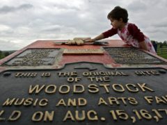 A girl playing on a memorial at the site of the Woodstock Music and Arts Fair in Bethel, New York (Mike Groll/AP)