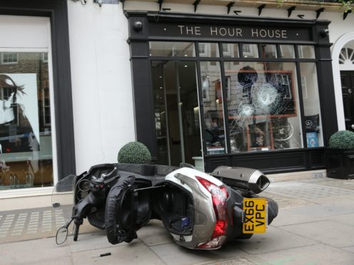 A moped outside The Hour House on Duke Street, Westminster, where moped-riding armed robbers targeted the luxury watch shop, making off with items stolen from the smashed shop window.