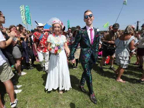 Mr and Mrs Watney celebrate their wedding at Glastonbury Festival (Yui Mok/PA)