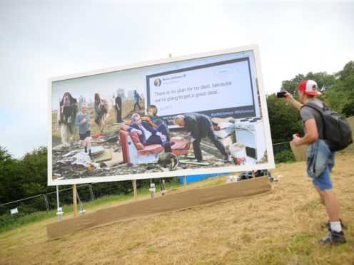 A billboard is unveiled on the first day of the Glastonbury Festival (Aaron Chown/PA)