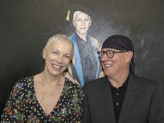 Annie Lennox with artist Gerard Burns (right) in front of the portrait (GCU/PA)