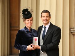 Bear Grylls and his wife Shara holding his OBE (Jonathan Brady/PA)