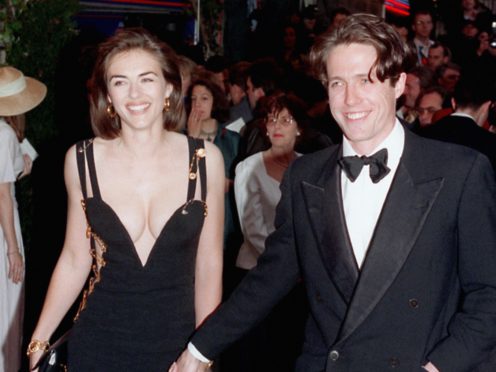 Hugh Grant and then girlfriend Liz Hurley (Michael Stephens/PA) revealing Versace evening dress. *27/4/99 Hollywood superstar Julia Roberts jetted into Britain to the premiere of her latest movie, Notting Hill, but was upstaged by co-star Hugh Grant’s girlfriend Liz Hurley and her dazzling dress. Model Hurley, the face of Estee Lauder, repeated the same trick she pulled off five years ago for the launch of Four Weddings And A Funeral when she wore a stunning Versace frock. For Notting Hill, the follow up to Four Weddings, she turned heads in a sheer and shimmering backless outfit, which was split from ankle to thigh and was again Versace.