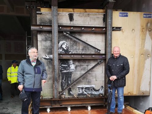 Art dealer John Brandler (left), with garage owner Ian Lewis, as Banksy’s Season’s Greetings mural (Adam Hale/PA)