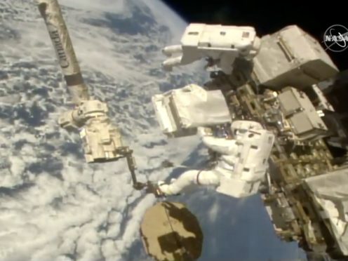 Italian astronaut Luca Parmitano, lower right, holds a bundle of new pumps during a spacewalk (Nasa/AP)