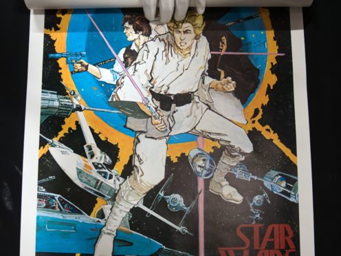 Prop Store poster consultant Mark Hochman unrolls a special one-sheet style poster for Star Wars: A New Hope (Andrew Matthews/PA)