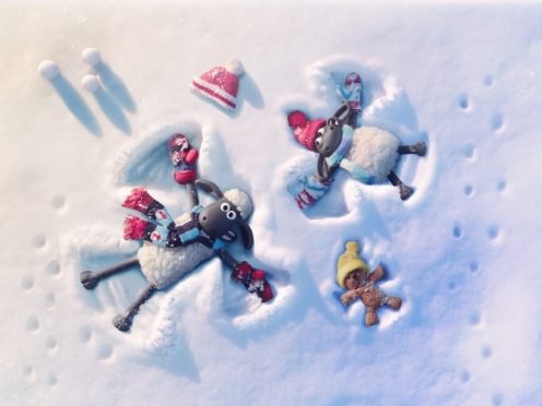Characters Shaun, Timmy and his teddy making snow angels (Aardman/BBC/PA)