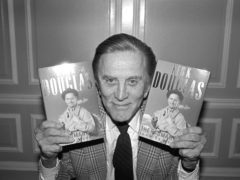 Hollywood actor Kirk Douglas posing with copies of his autobiography The Ragman’s Son (PA)