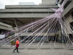 The National Theatre, on the South Bank, in London, is wrapped in tape at the launch of the #MissingLiveTheatre campaign by UK theatre designers (Dominic Lipinski/PA)