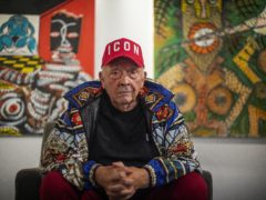 Fashion and portrait photographer David Bailey sits in front of two of his 50 unseen oil paintings (Victoria Jones/PA)