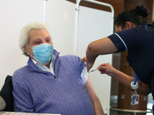 Entertainer Lionel Blair receives the first of two injections with a dose of the Pfizer/BioNTech Covid-19 vaccine at a NHS vaccine centre (Steve Parsons/PA)