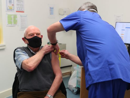 Pharmacist Andrew Hodgson administers a dose of the coronavirus vaccine to Robert Salt, 82, at Andrews Pharmacy in Macclesfield, Cheshire (Peter Byrne/PA)