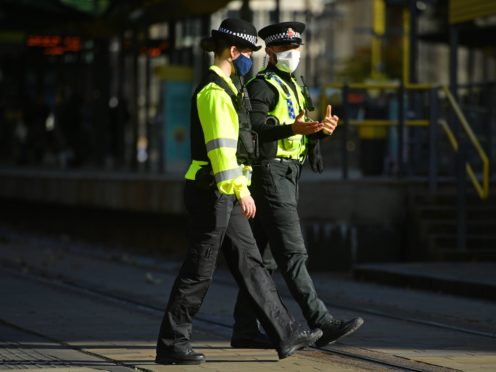 Police officers wearing face masks in St Peter’s Square, Manchester (Jacob King/PA)